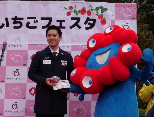 ミャクミャクにいちごとメッセージカードをプレセントする吉村知事