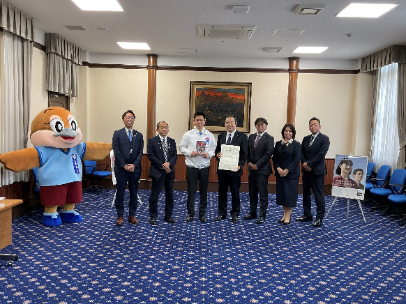 SOMPOケア株式会社の代表者ら、もずやん、水野教育長、吉田福祉部長と記念撮影する知事