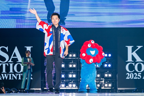 手を振りながらランウェイを歩く知事