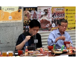 松井市長らとともに道頓堀名物の串カツなどを食べる知事