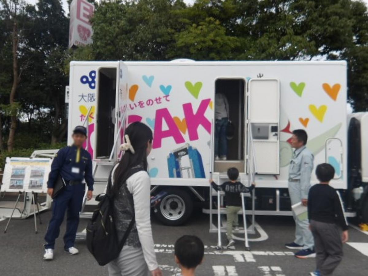 大阪府の自走式水洗トイレカーに来場者が関心を持っている様子