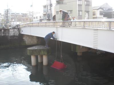 河川からソファを引き上げる様子