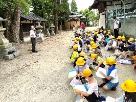 建物の前で説明を受ける児童