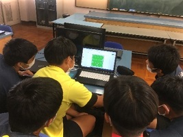 パソコンを囲んで話し合う生徒たち